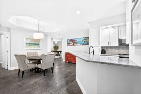 a living room with stainless steel appliances granite countertop furniture a sink a kitchen island a stove and a window