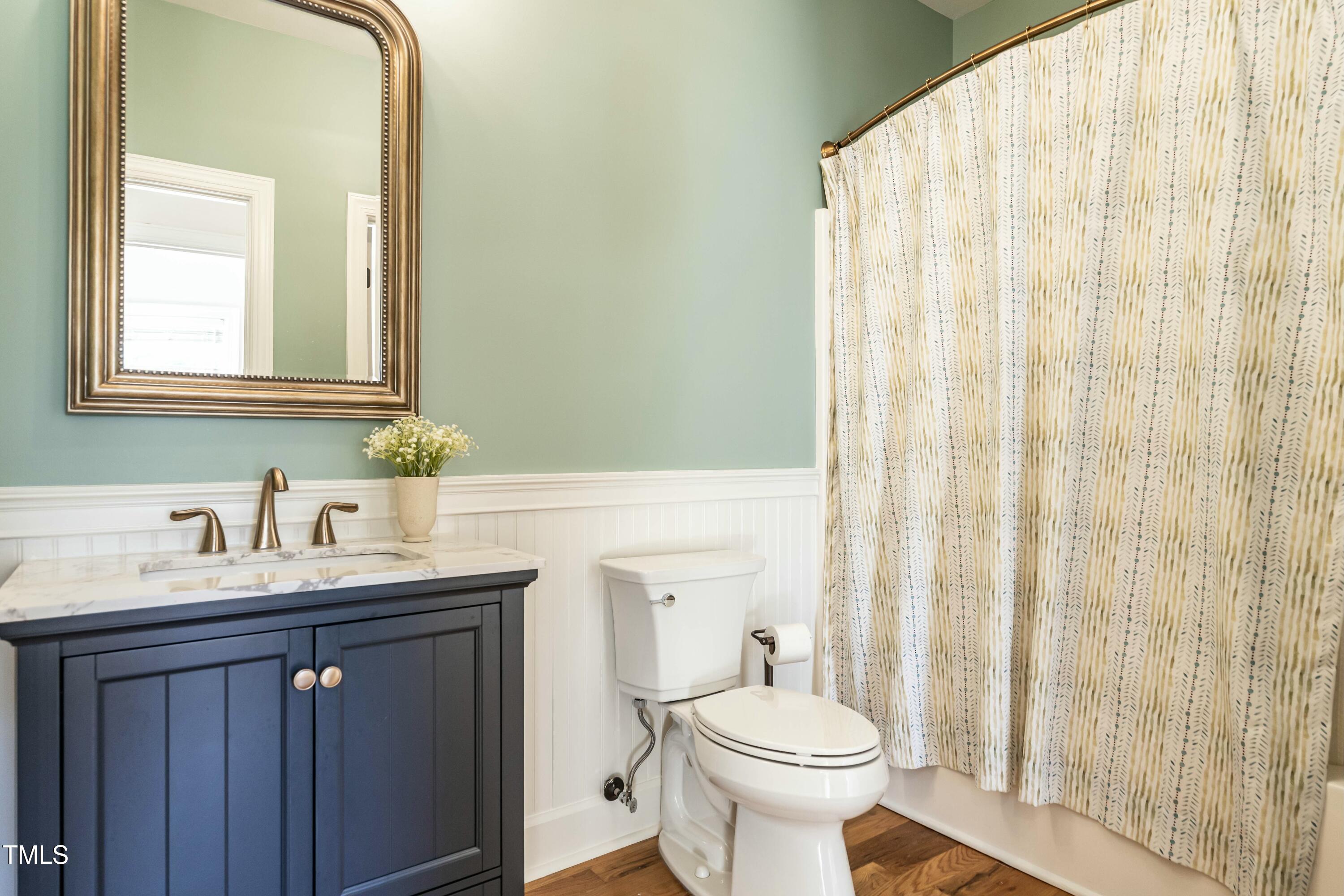708 Kimbrough Street Raleigh, NC 27608 - Photo 14 of 36 a bathroom with a sink a toilet and a mirror