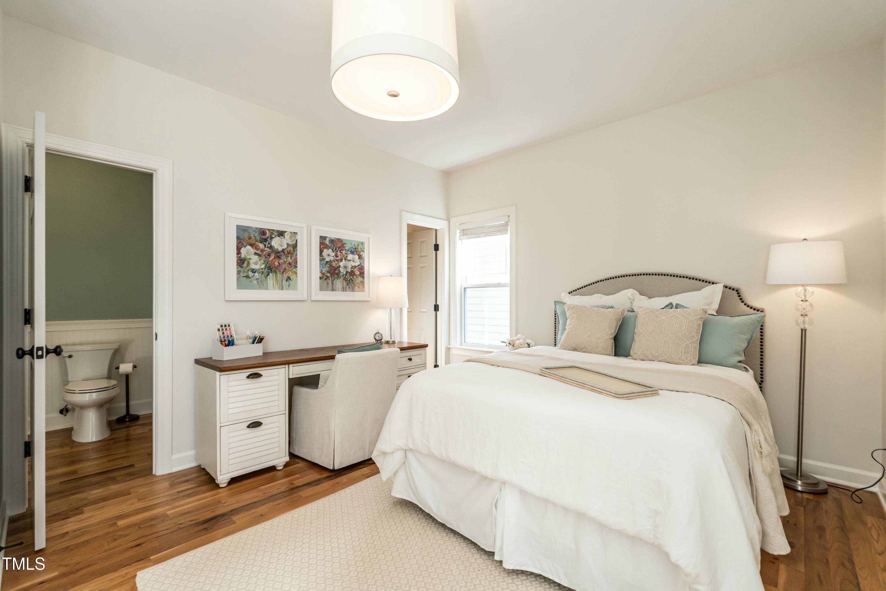 708 Kimbrough Street Raleigh, NC 27608 - Photo 15 of 36 a bedroom with a bed and a chandelier
