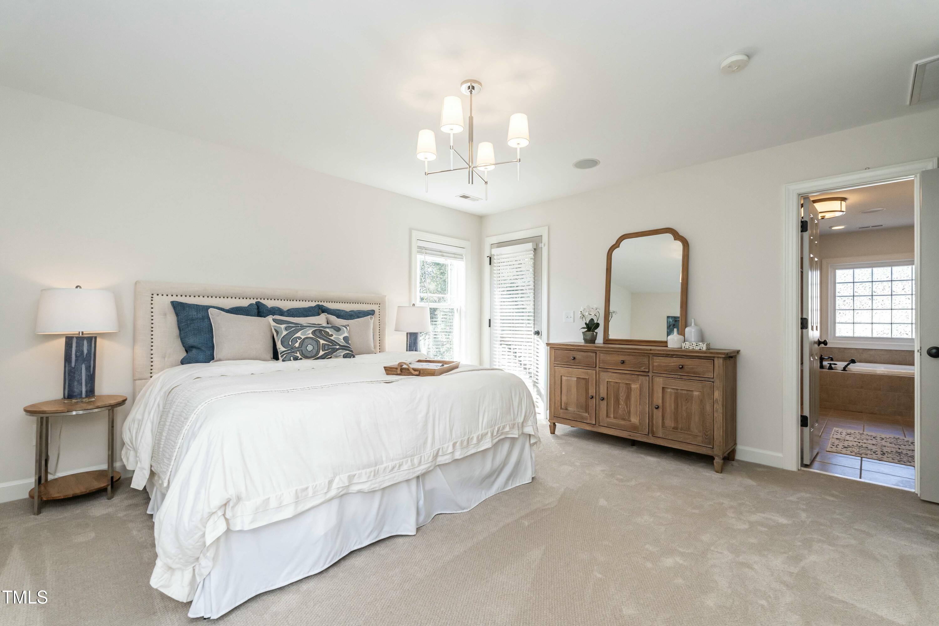 708 Kimbrough Street Raleigh, NC 27608 - Photo 20 of 36 a bedroom with bed and a chandelier