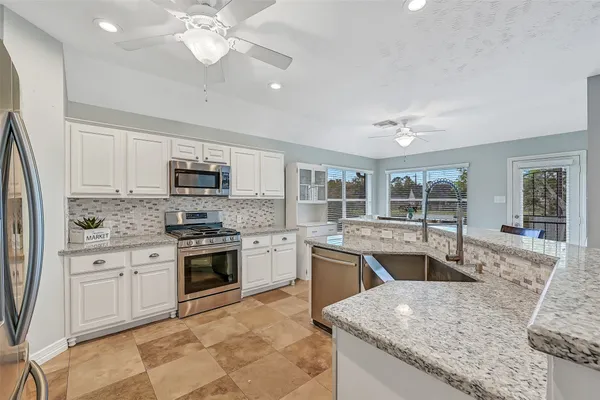 a large kitchen with cabinets appliances and a counter space