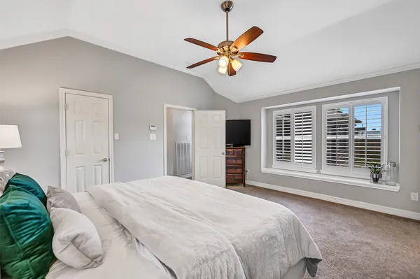 a spacious bedroom with a bed chandelier and a window