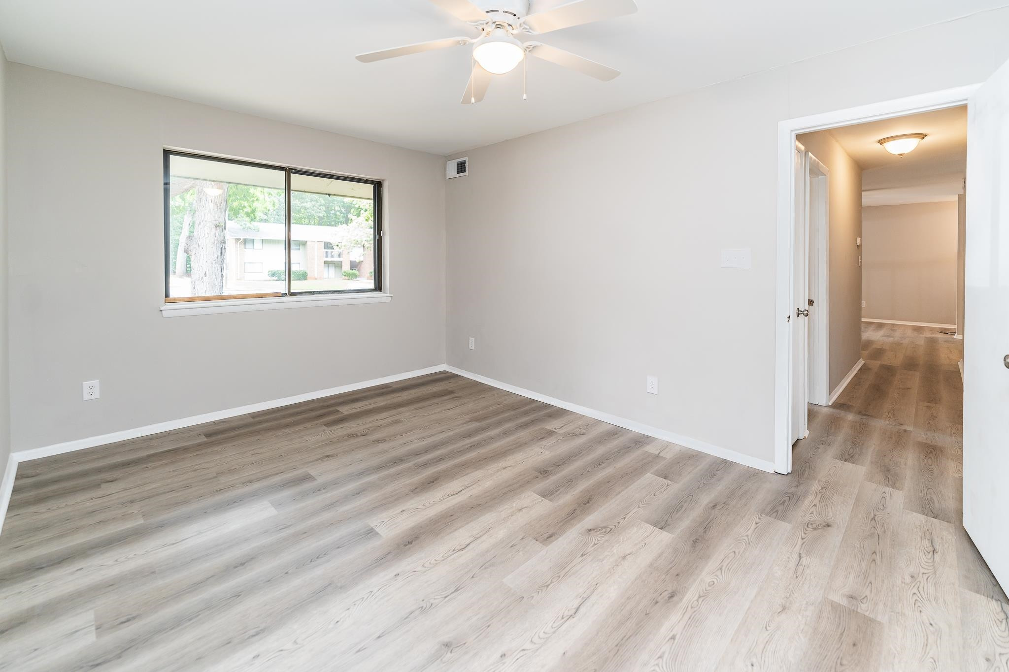 1281 Schaub Drive, Unit G Raleigh, NC 27606 - Photo 6 of 10 an empty room with wooden floor and windows