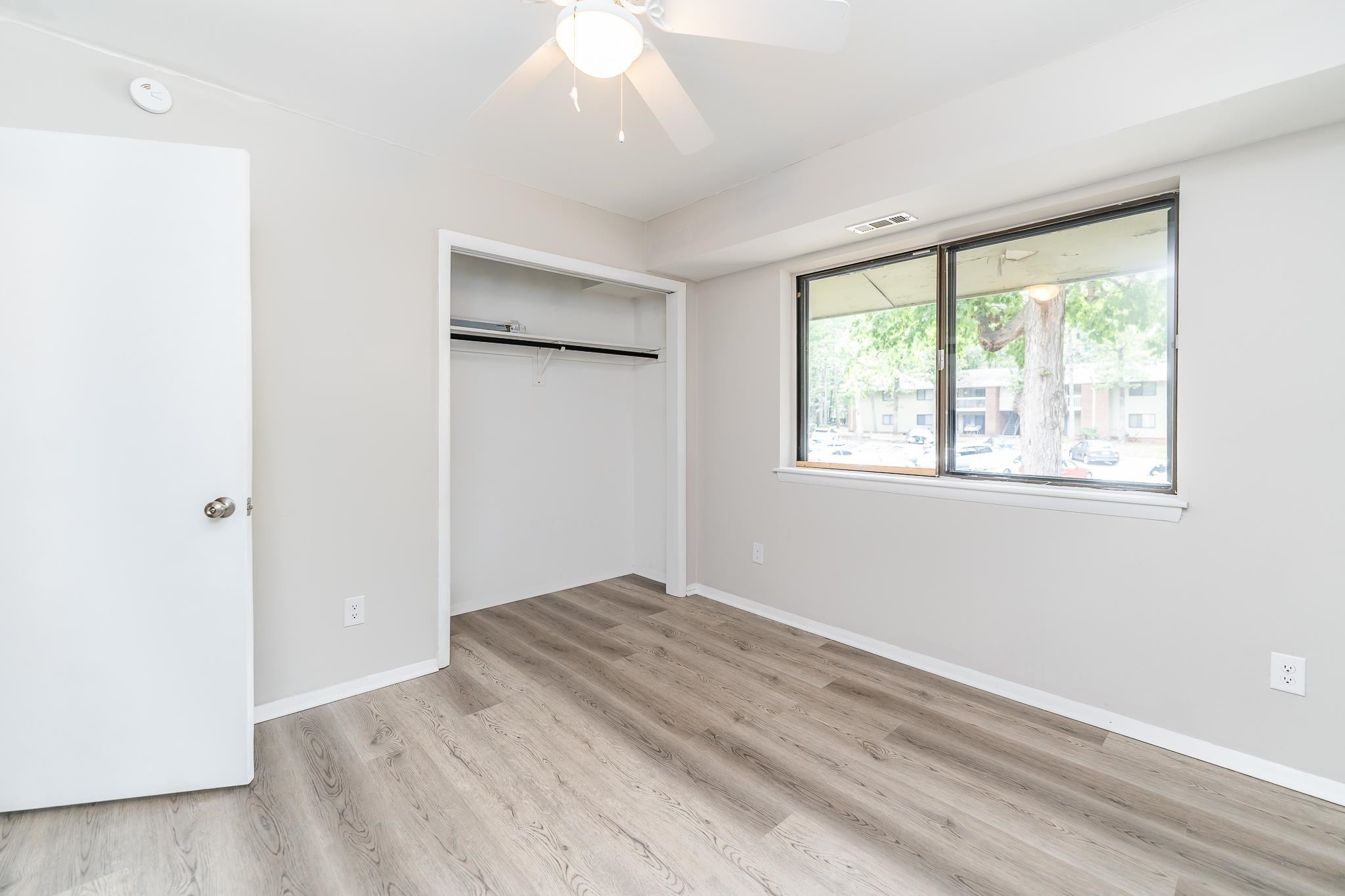 1281 Schaub Drive, Unit G Raleigh, NC 27606 - Photo 9 of 10 a view of an empty room with wooden floor and a window