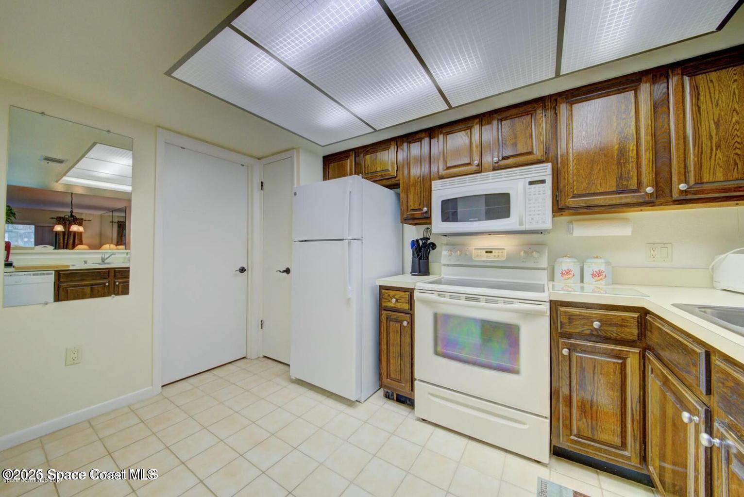 227 Augusta Way Melbourne, FL 32940 - Photo 12 of 38 a kitchen with a stove cabinets and a refrigerator