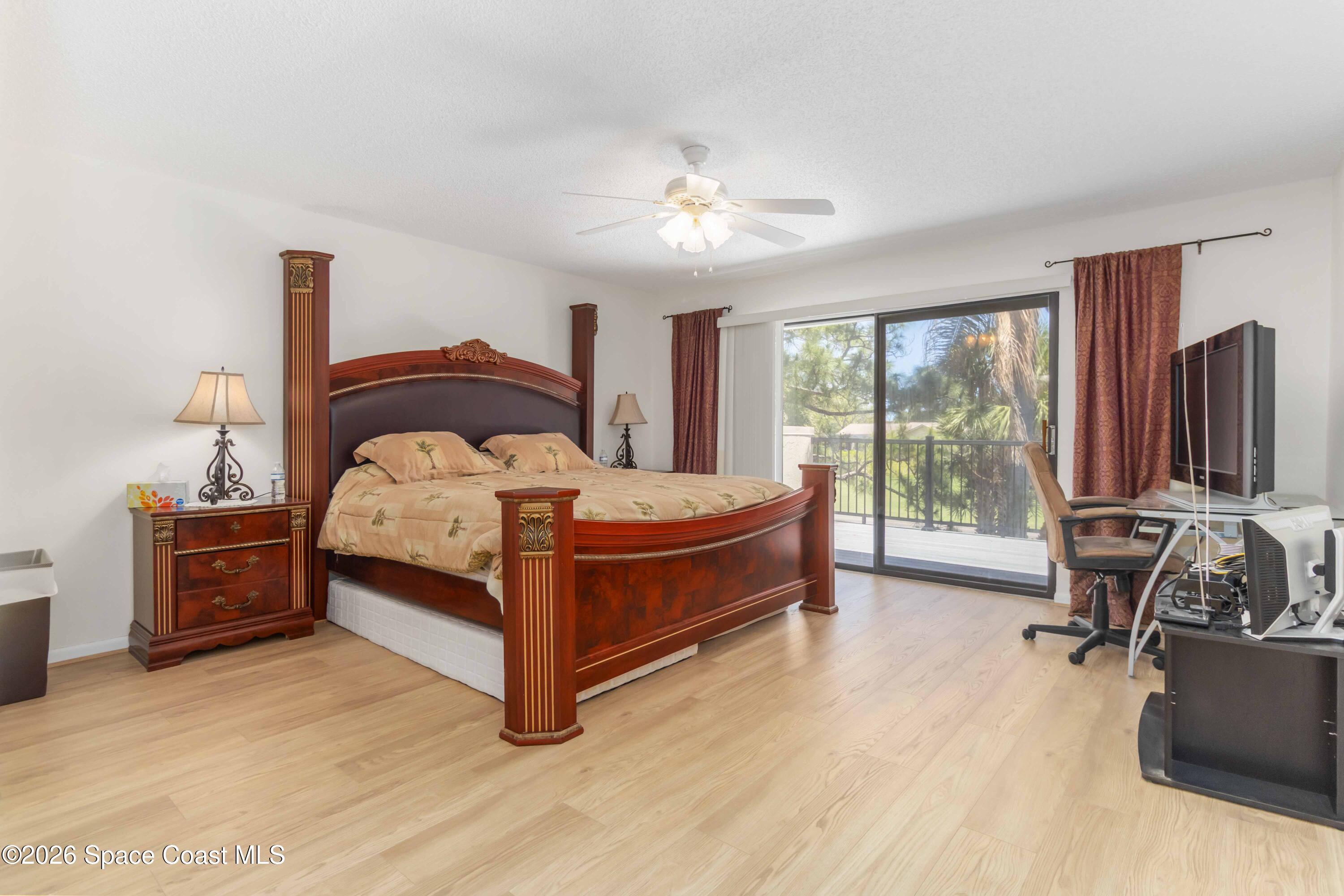 227 Augusta Way Melbourne, FL 32940 - Photo 19 of 38 a bedroom with a bed and large windows