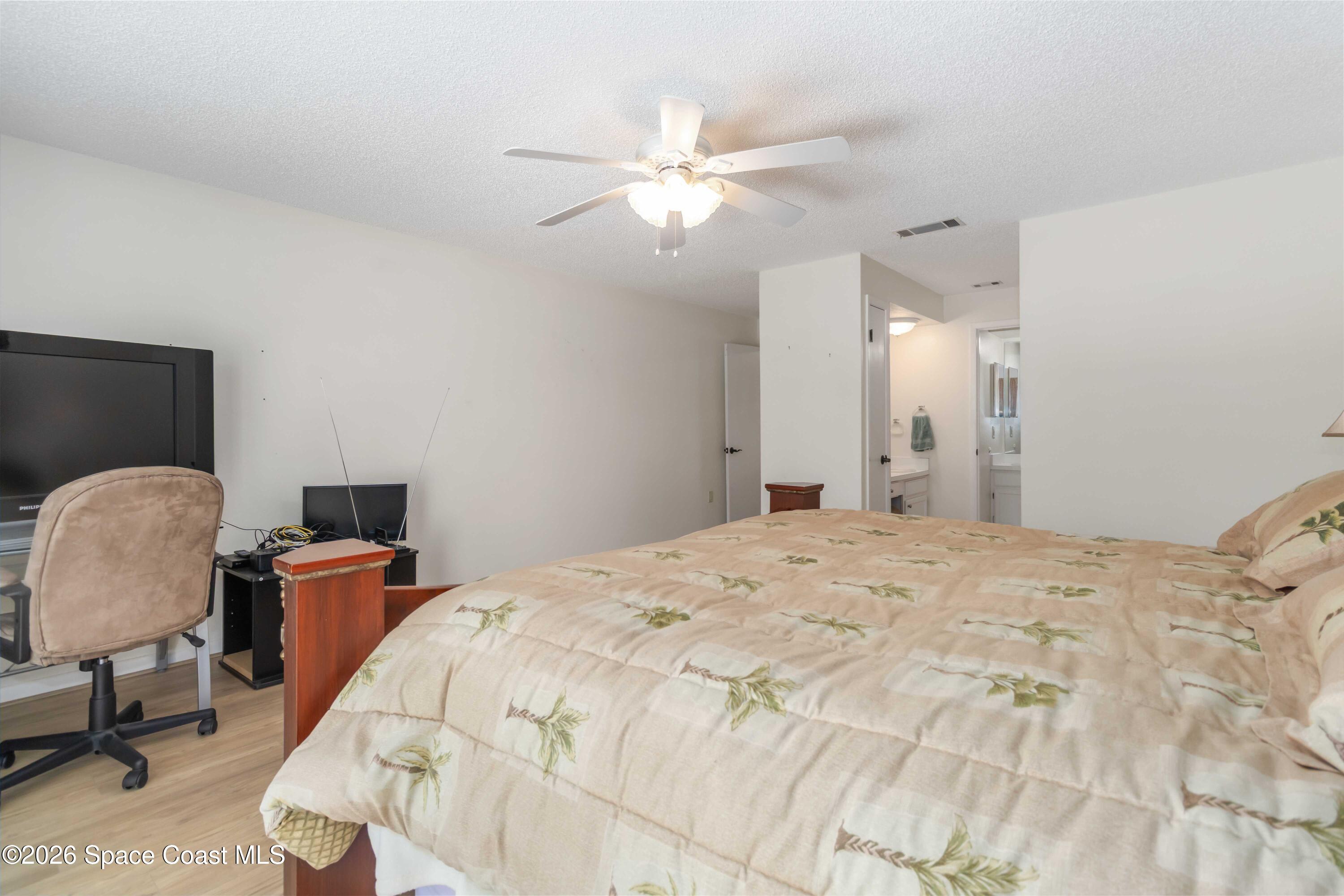 227 Augusta Way Melbourne, FL 32940 - Photo 21 of 38 a bedroom with a bed and chair