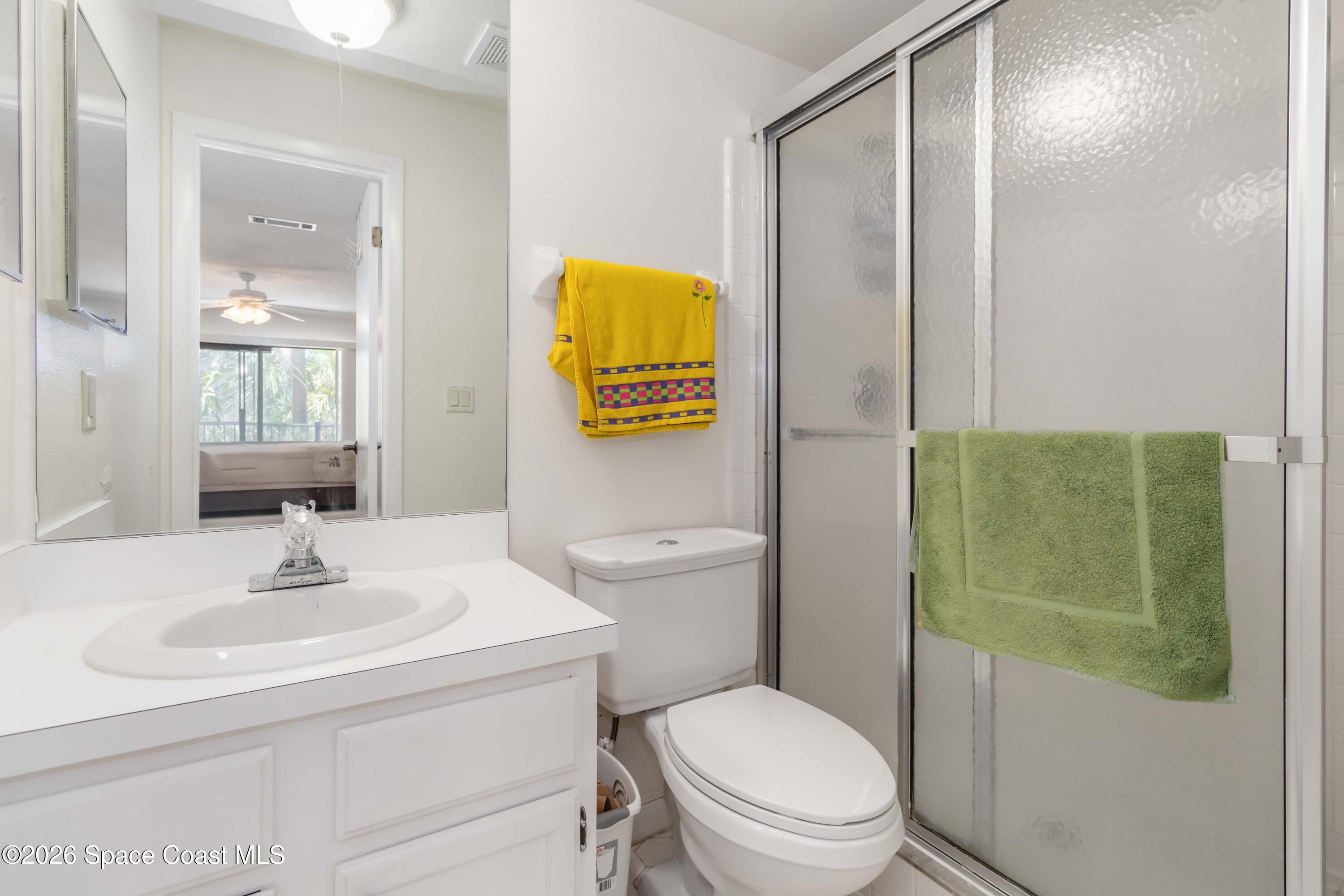 227 Augusta Way Melbourne, FL 32940 - Photo 25 of 38 a bathroom with a toilet sink vanity and mirror