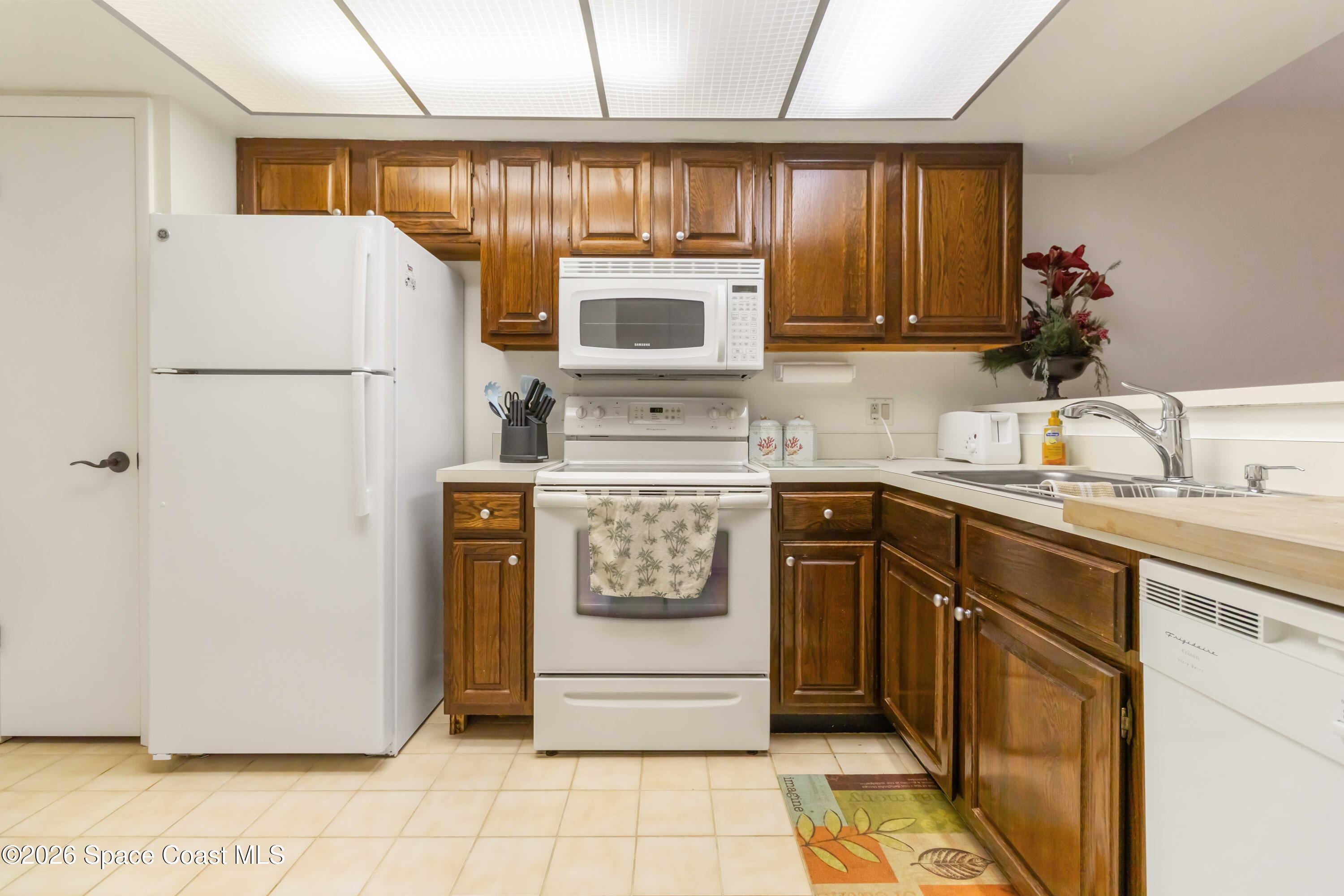 227 Augusta Way Melbourne, FL 32940 - Photo 10 of 38 a kitchen with a refrigerator sink stove and cabinets
