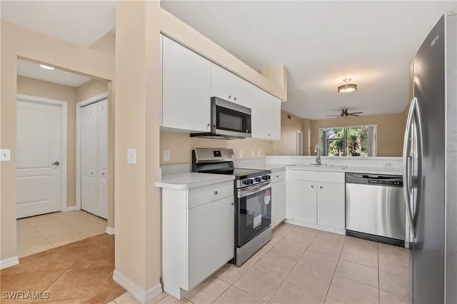a kitchen with white cabinets and stainless steel appliances
