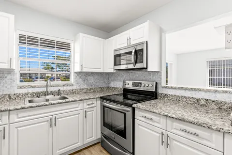 a kitchen with granite countertop cabinets stainless steel appliances and a sink