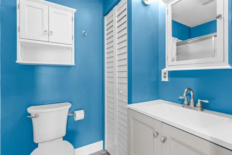 a bathroom with a toilet sink and mirror