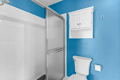 a white toilet sitting next to a shower