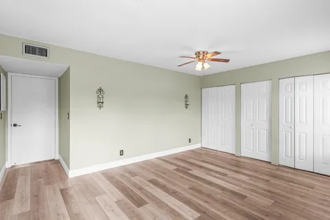 a view of a room with a ceiling fan and hardwood floor
