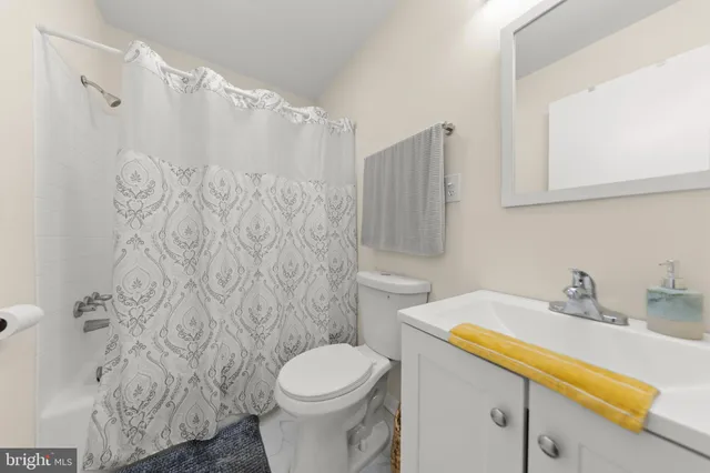 a living room with furniture and a flat screen tv with kitchen view