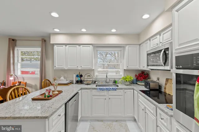 a kitchen with stainless steel appliances granite countertop a sink stove and cabinets