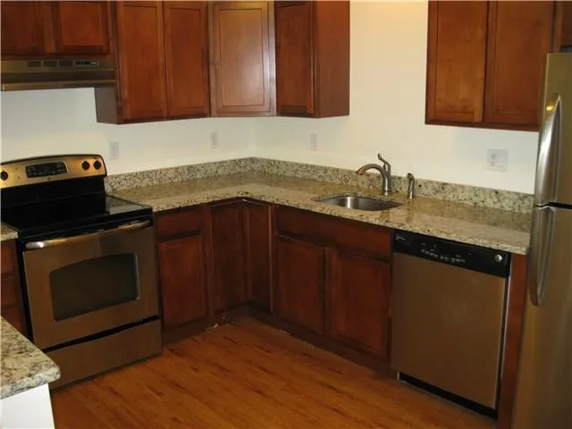 a kitchen with granite countertop wood cabinets and stainless steel appliances