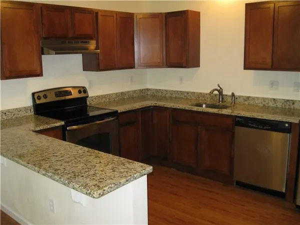 a kitchen with wooden cabinets a sink and a stove