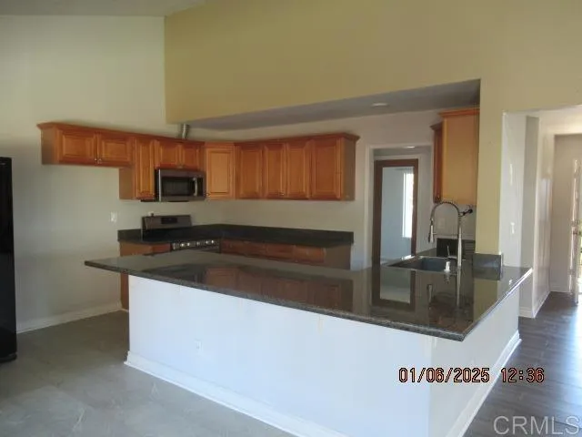 a kitchen with granite countertop a stove and a sink