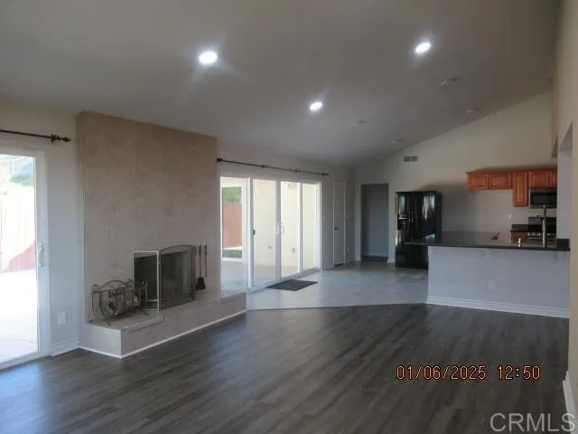 an empty room with wooden floor and fireplace