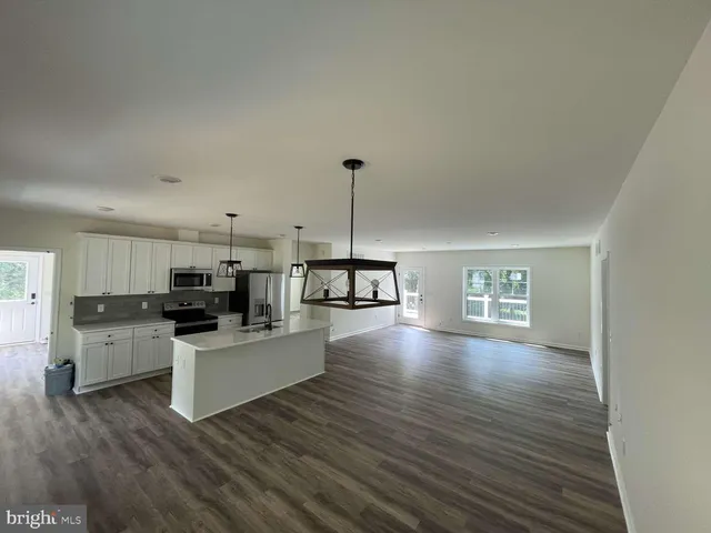 a living room with furniture and kitchen view