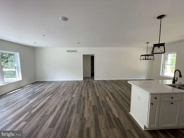 a view of a kitchen with wooden floor and a sink