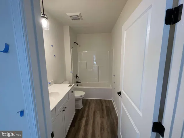 a bathroom with a sink a toilet a tub and shower