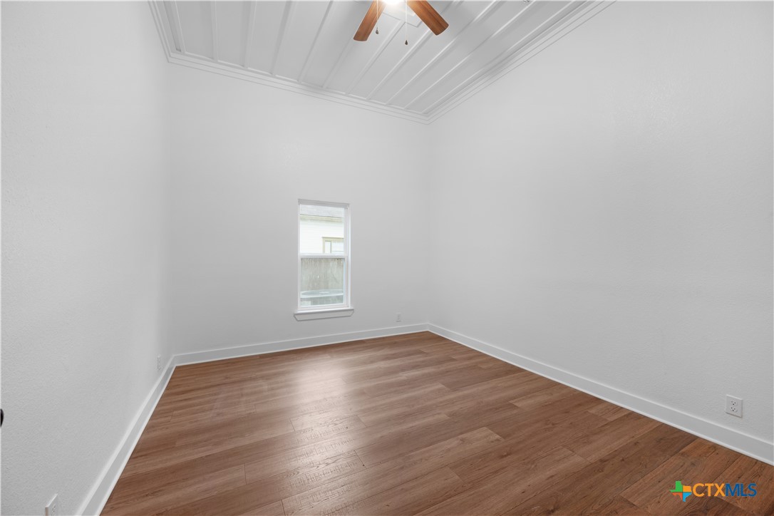 607 West 3rd Street Eddy, TX 76524 - Photo 12 of 29 an empty room with wooden floor and windows