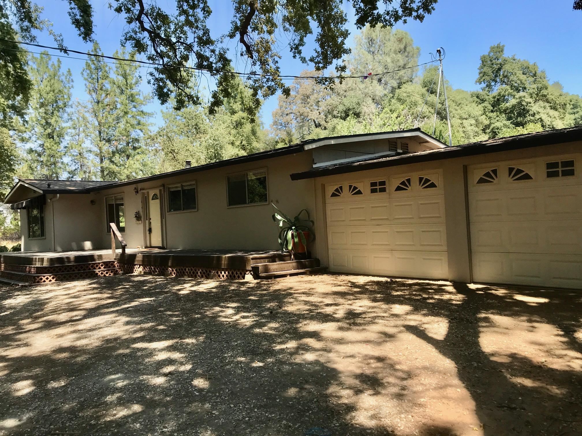 18191 Woodham Carne Road Sonora, CA 95370 - Photo 43 of 47 a backyard of a house with large trees and outdoor seating