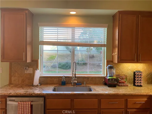 a view of a sink and dishwasher with wooden floor