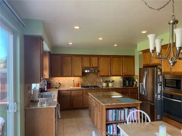 a kitchen with a refrigerator a sink and wooden cabinets