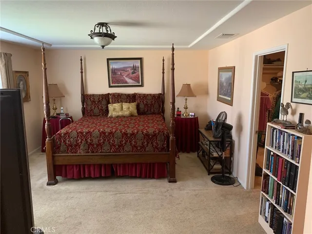 a bedroom with a bed and a book shelf