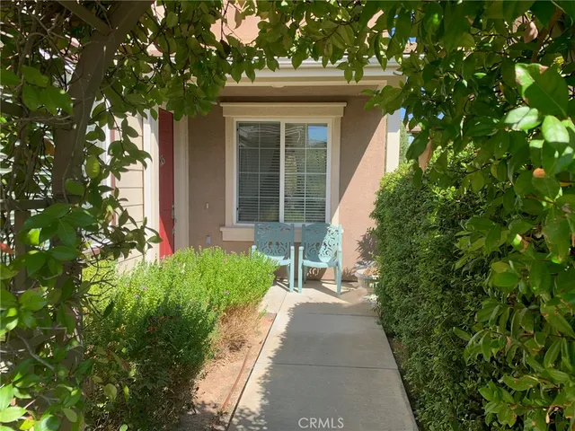 a front view of a house with a yard and potted plants