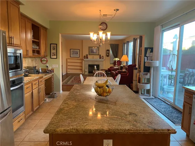 a view of a kitchen with kitchen island granite countertop wooden floor stainless steel appliances and cabinets