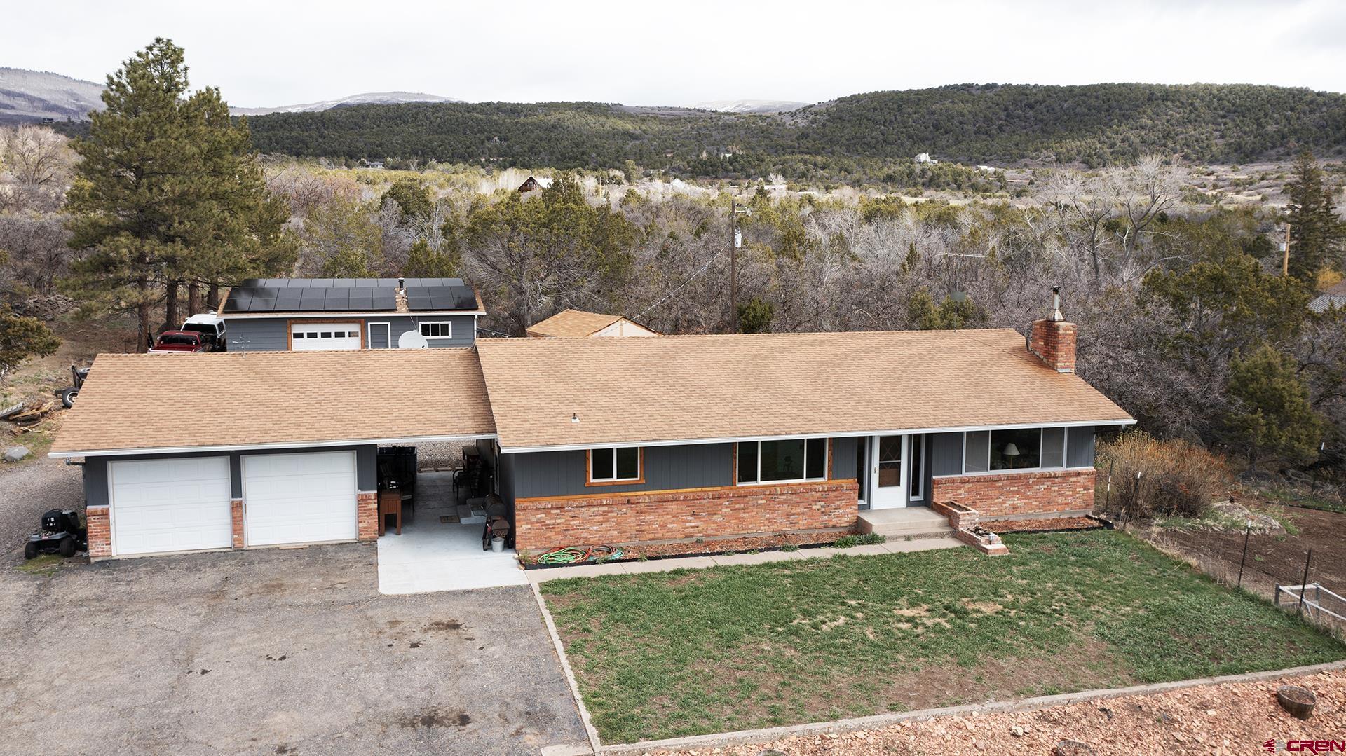 22755 Uintah Road Cedaredge, CO 81413 - Photo 2 of 35 an aerial view of a house with a yard table and chairs
