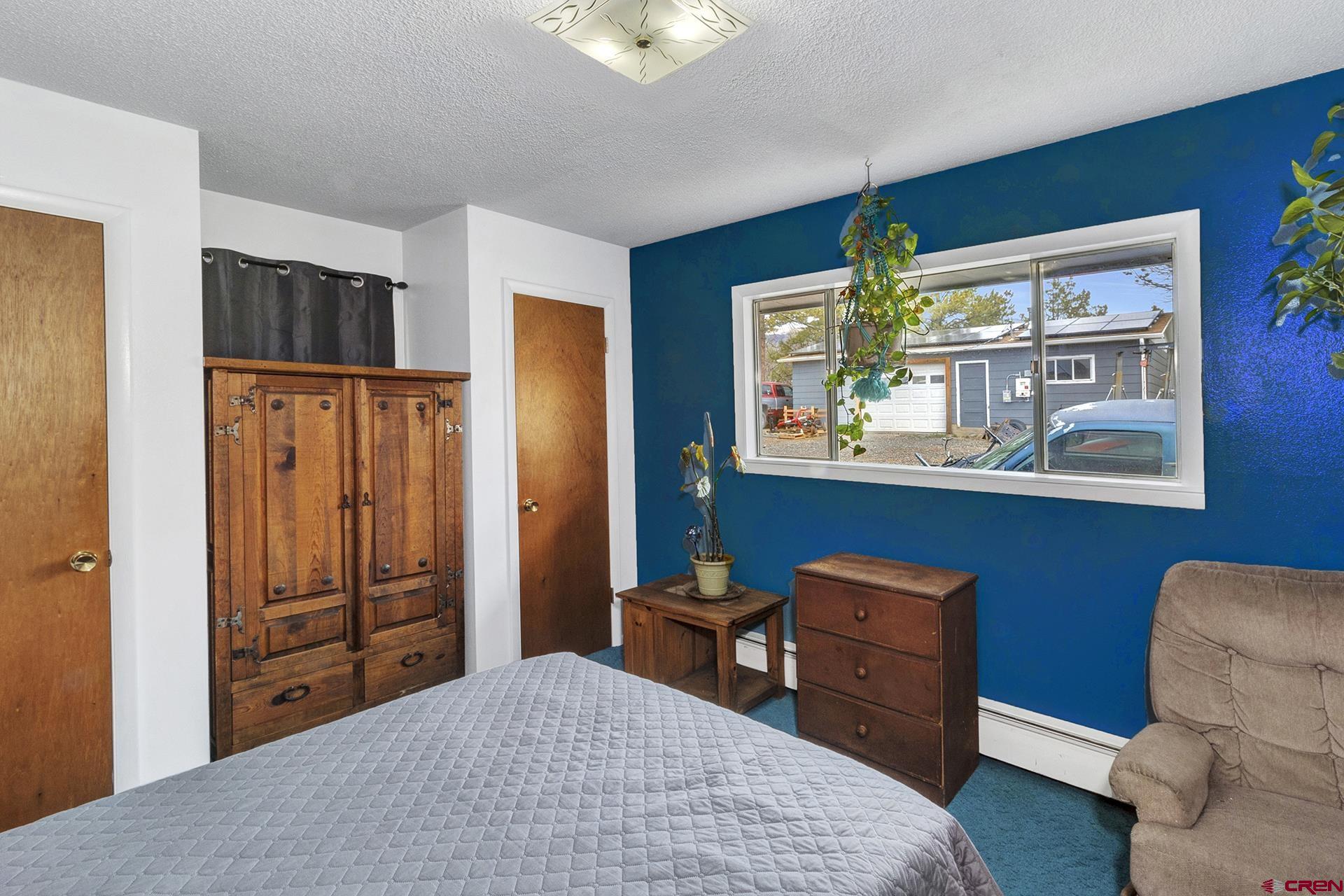 22755 Uintah Road Cedaredge, CO 81413 - Photo 25 of 35 a bedroom with a bed and wooden floor