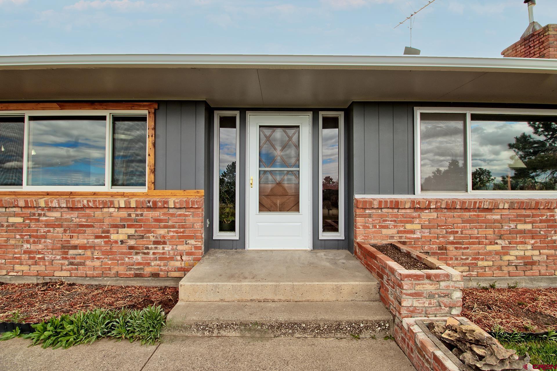 22755 Uintah Road Cedaredge, CO 81413 - Photo 3 of 35 a front view of a house with a garden