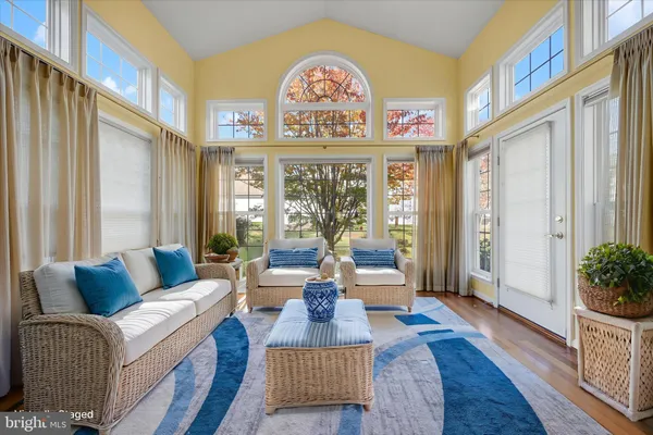 a living room with furniture a chandelier and a large window