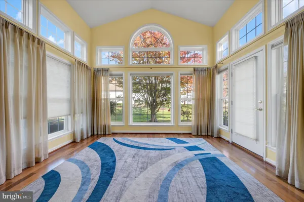a view of a spacious bathroom with a tub and a large window