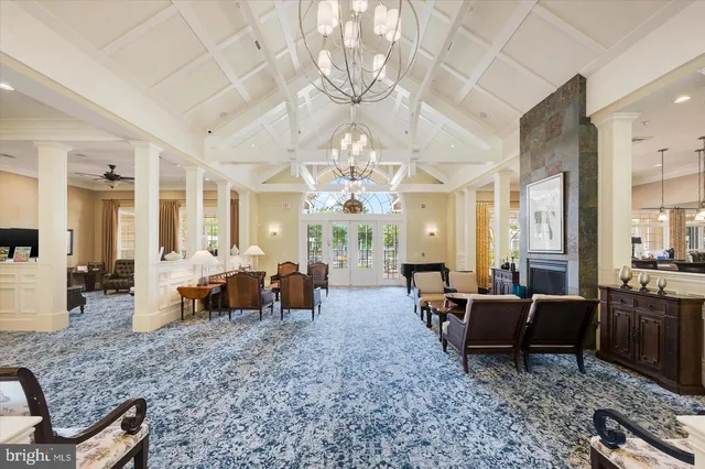 a living room with furniture chandelier and large windows