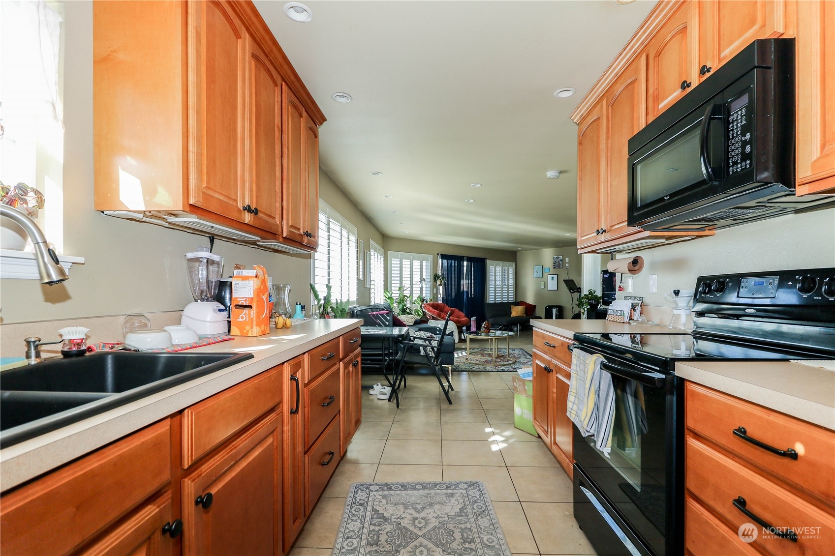 405 Northwest Market Street Seattle, WA 98107 - Photo 12 of 33 a kitchen with stainless steel appliances a stove a sink dishwasher a microwave oven and a dining table with wooden cabinet