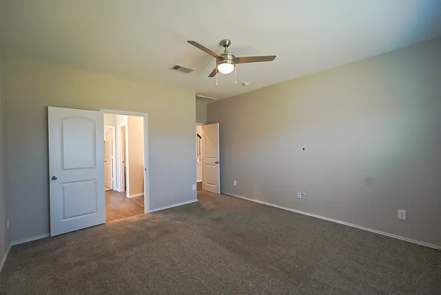 an empty room with closet and windows