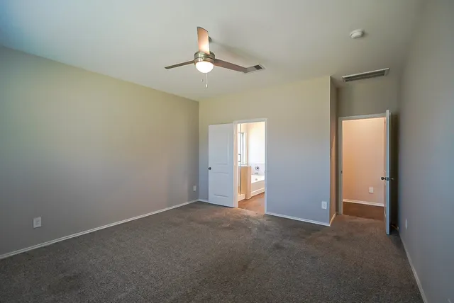 an empty room with chandelier fan