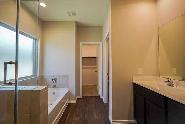a bathroom with a tub sink and mirror