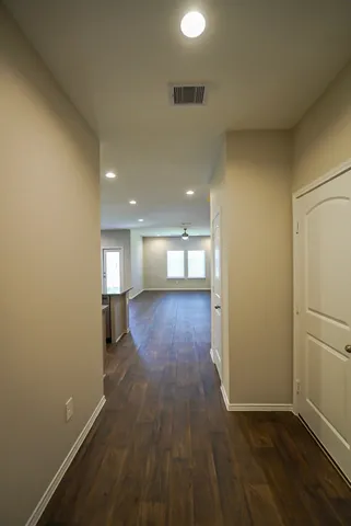 a view of empty room with wooden floor