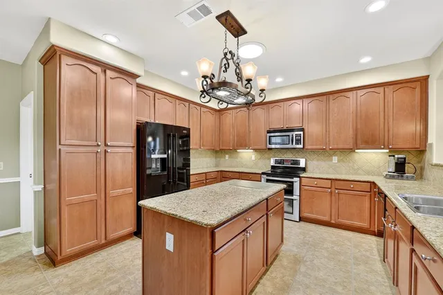 a kitchen with a refrigerator a sink and cabinets