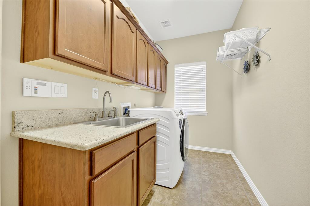 9813 Callaway Court Denton, TX 76207 - Photo 19 of 39 a utility room with a sink dryer and washer