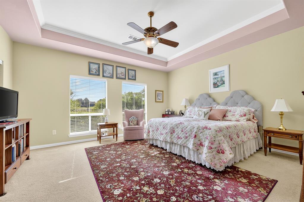 9813 Callaway Court Denton, TX 76207 - Photo 21 of 39 a spacious bedroom with a bed and a large window with the outer view