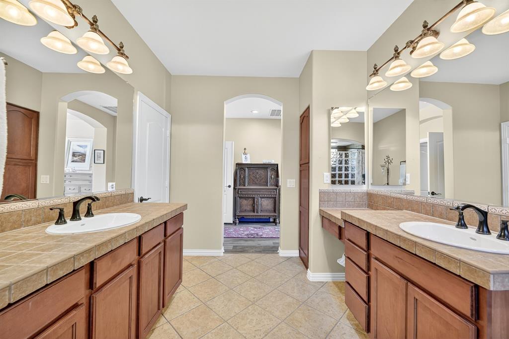 9813 Callaway Court Denton, TX 76207 - Photo 24 of 39 a spacious bathroom with a sink double vanity and a mirror
