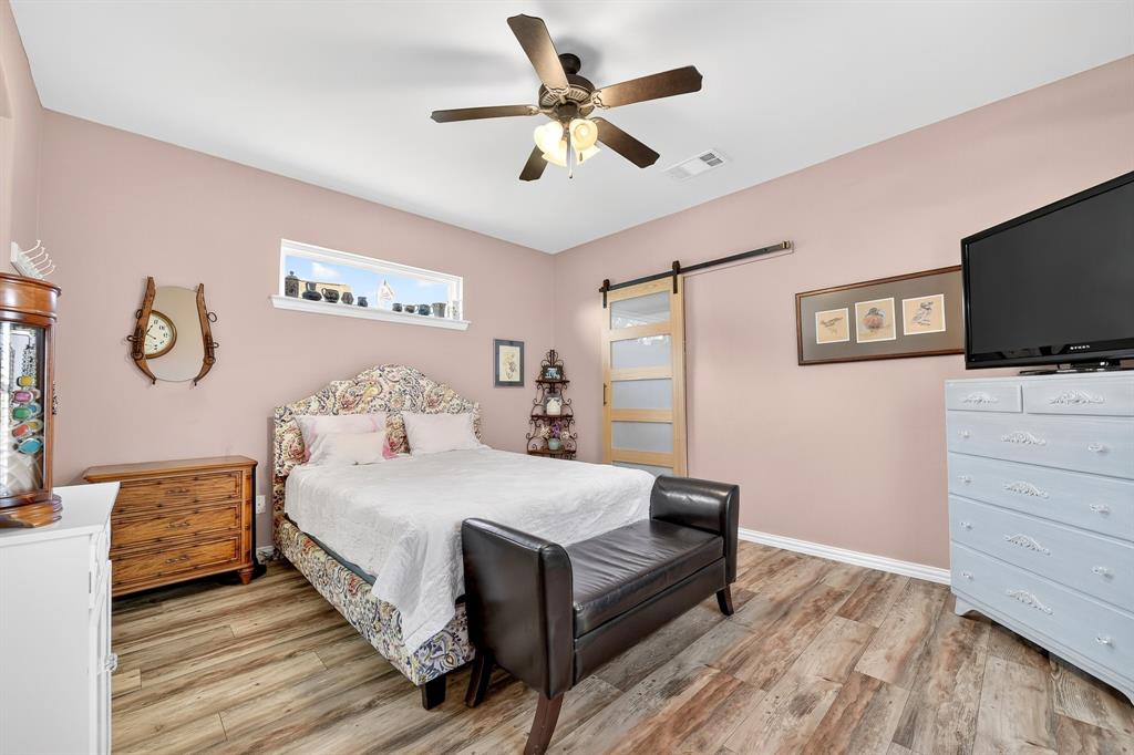 9813 Callaway Court Denton, TX 76207 - Photo 25 of 39 a bedroom with a bed and a flat tv screen on dresser